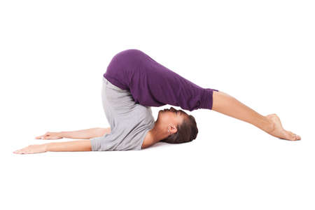 Young woman doing yoga exercise Halasana (Plow Pose). Isolated on white backgroundの写真素材