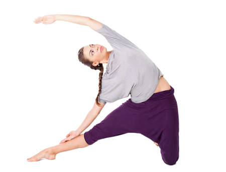 Young woman performs gymnastic exercise isolated on white backgroundの写真素材