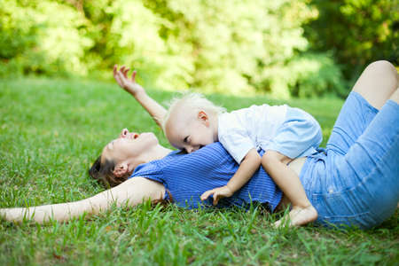Mother and son having fun on the grass in a parkの写真素材