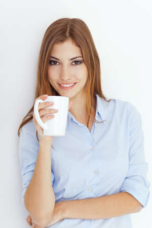 Portrait of a young woman with cup of tea or coffee の写真素材