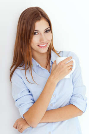 Portrait of a young woman with cup of tea or coffee の写真素材
