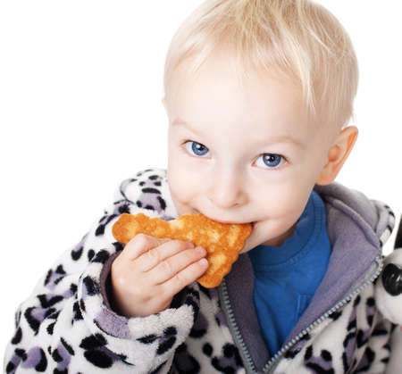 Cute little boy with his teddy eating a cookie isolated on white backgroundの写真素材