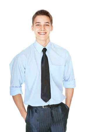Portrait of handsome young laughing successful businessman standing with hands in pockets isolated on white backgroundの写真素材