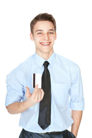 Portrait of laughing young man in white shirt holding a credit card isolated on white backgroundの写真素材