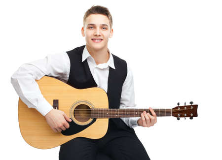 Young man playing on acoustic guitar sitting on a chair isolated on white backgroundの写真素材