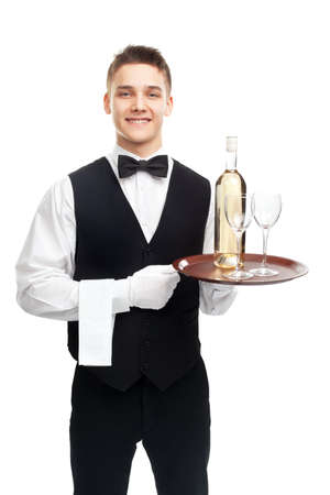 young happy smiling waiter with bottle of white wine and stemware glass on tray isolated on white backgroundの写真素材