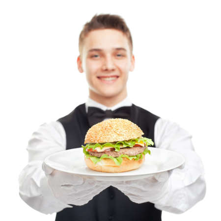 young happy smiling waiter holding hamburger on plate isolated on white backgroundの写真素材
