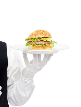 Waiter hand in white gloves holding hamburger on plate isolated on white backgroundの写真素材