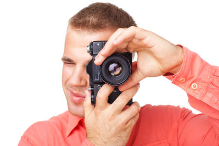 Young photographer taking pictures with his camera isolated on white backgroundの写真素材