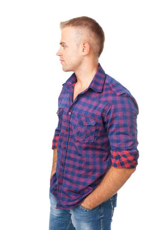 Portrait of serious young man standing with hands in pockets isolated on white backgroundの写真素材