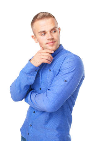 Portrait of smiling young man wearing a blue shirt looks aside isolated on white backgroundの写真素材