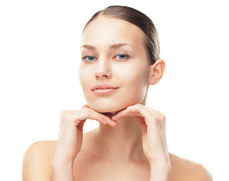 Close-up portrait of beautiful young woman with healthy clean skin touching her face isolated on white の写真素材