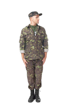 Full length portrait of young army soldier standing in attention and looking away isolated on white backgroundの写真素材