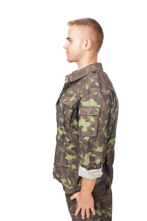 side view of young army soldier standing in attention isolated on white background の写真素材