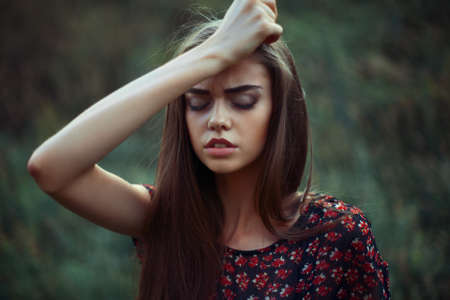 Portrait of young worried woman on the natureの写真素材