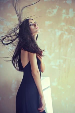 Sensual beautiful young woman with developing hair on textured backgroundの写真素材