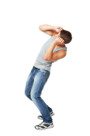 Young man defending himself from something on top isolated on white backgroundの写真素材