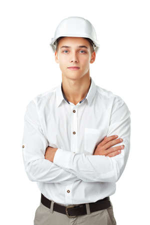 Portrait of young engineer wearing a white helmet standing with hands folded against isolated on white backgroundの写真素材