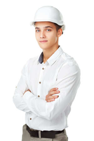 Portrait of young engineer wearing a white helmet standing with hands folded against isolated on white backgroundの写真素材