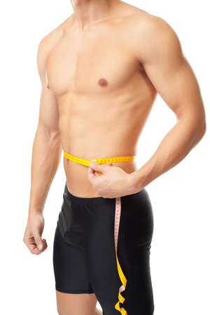 Muscular young man measuring waist isolated on white background  Male torsoの写真素材