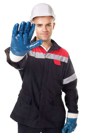 Portrait of young worker wearing safety protective gear doing stop symbol isolated on white backgroundの写真素材