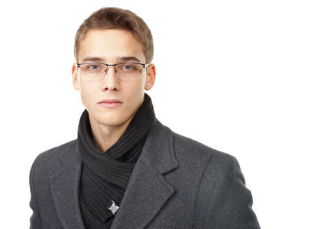 Portrait of elegant young man wearing coat and glasses isolated on white backgroundの写真素材