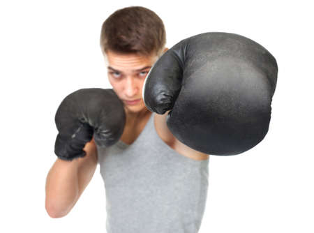 Portrait of young boxer throwing a punch at the camera isolated on white background  Focus on boxing gloveの写真素材