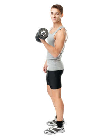 Full length portrait of young fit muscular man exercising with dumbbells for training his biceps isolated on white backgroundの写真素材