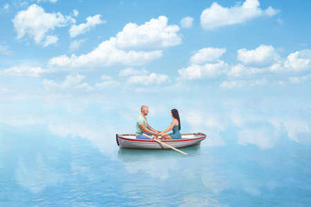 young couple in Love hold hands on boat in seaの写真素材