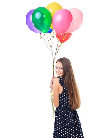 Portrait of beautiful young happy woman in polka dot dress with colorful balloons turning around isolated on white backgroundの写真素材