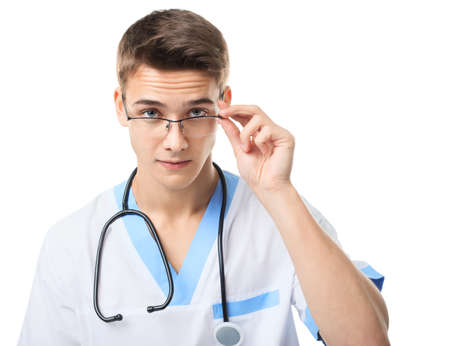 Portrait of young doctor with stethoscope looking over glasses isolated on white backgroundの写真素材