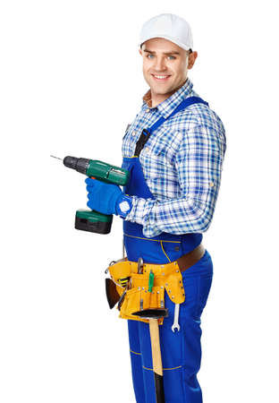 Portrait of happy young male construction worker with electric drill isolated on white backgroundの写真素材