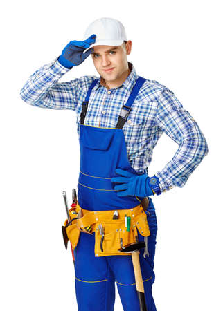 Portrait of young male construction worker with tool belt touching his white cap isolated on white backgroundの写真素材