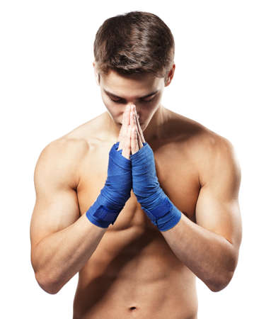 Young handsome male fighter standing concentrated before fight with putting palms together isolated on white backgroundの写真素材