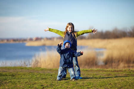Happy sister and brother having fun beside the river. Happy lifestyle kidsの写真素材