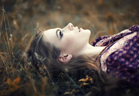 portrait of beautiful hippie girl lying on the grassの写真素材