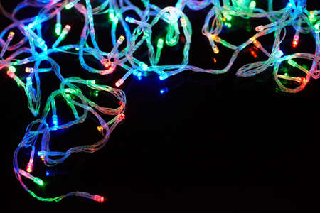 Christmas lights on black background with copy space. Decorative garland