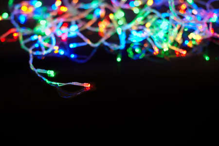 Christmas lights on black background with copy space. Decorative garlandの写真素材
