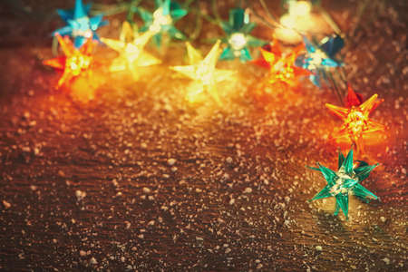 Christmas lights frame on wooden background with copy space. Decorative garland