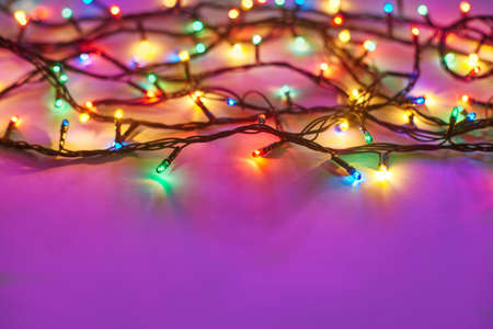 Christmas lights on dark pink background with copy space. Decorative garlandの写真素材