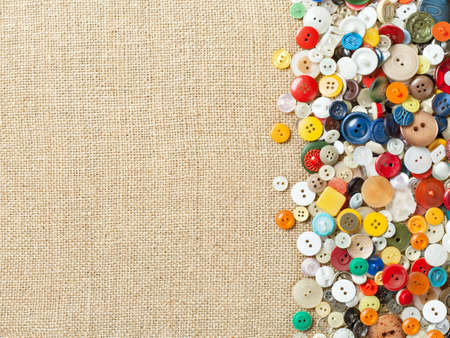 Colourful sewing buttons on fabric texture background with copy spaceの写真素材