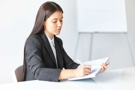 Young beautiful business woman working in the officeの写真素材