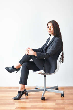 Portrait of young business woman sitting on chair in the officeの写真素材
