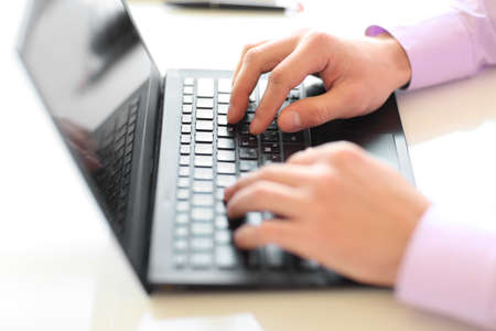 Male hands typing on laptop keyboardの写真素材