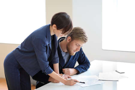 Business partners discussing documents and ideas at meeting in the officeの写真素材