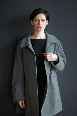Portrait of young confused woman on black wall backgroundの写真素材
