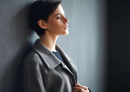 Portrait of tired beautiful woman on dark backgroundの写真素材