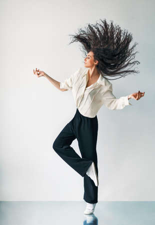 Happy jumping dancing girl with flying hairの写真素材
