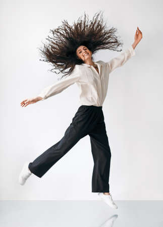 Happy freedom jumping girl with flying hairの写真素材