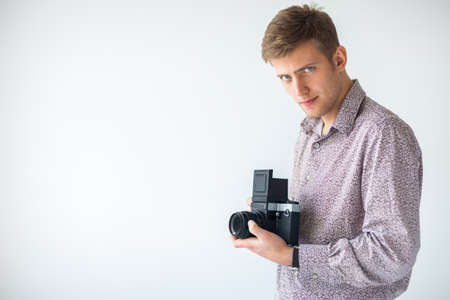 Portrait of handsome man with old medium format camera in studio with copy spaceの写真素材